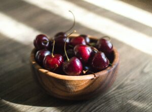 bunch of red cherries in brown bowl