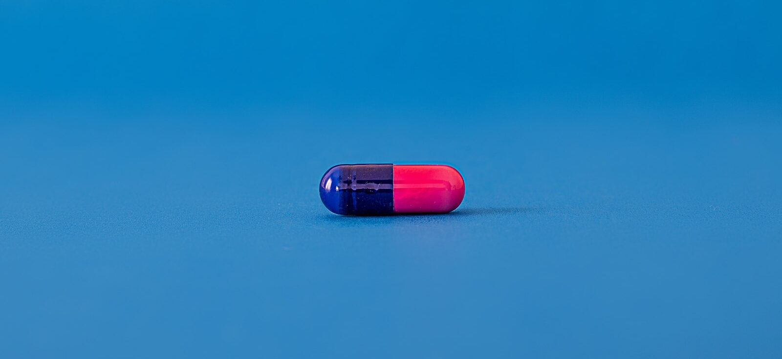 red and blue pill on blue surface